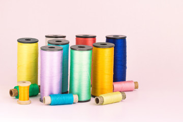 Sewing kit. Spools of thread   Isolated on pink background.