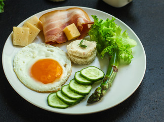 Fototapeta na wymiar breakfast, healthy food (scrambled eggs, bacon, lettuce, asparagus, cucumbers, cheese). food background. copy space