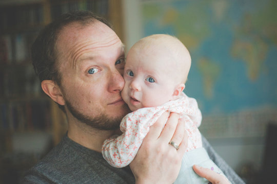 Portrait of father holding his baby daughter