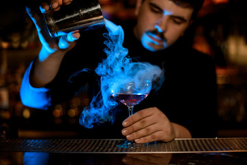 Fototapeta Bartender uses shaker to make an alcohol cocktail obraz