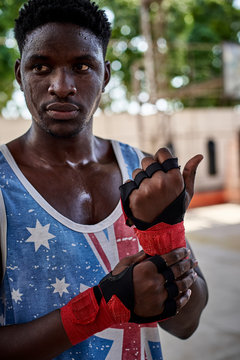 Portrait of serious boxer applying bandages