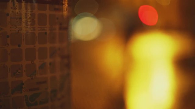 Bokeh light and map of Barcelona in the night. Wet streets and reflections in the pavement. Yellow, red and white light. Eixample grid closeup. Night in the city. Urban plan.