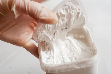 White acrylic glazing putty for wood and metal, interior and exterior use on a putty knife showing...