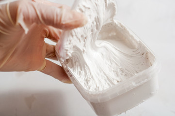 White acrylic glazing putty for wood and metal, interior and exterior use on a putty knife showing...