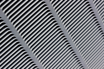 Metal grille for gray ventilation. Industrial background. Black horizontal and diagonal stripes on a gray background.