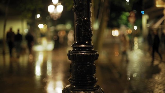 Barcelona city night. Rain in medieval town. Mirror reflects light and colour. Raindrops falling on the brick pavement. European holidays. Nightlife in Barna. Shadows and background colour textures