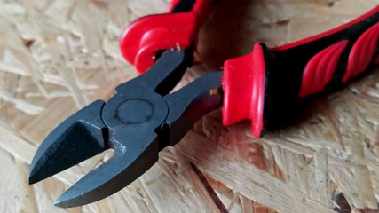 Close up of diagonal wire cutting pliers with red handle
