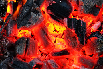 Background from a fire, firewoods and decaying red coals