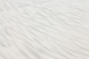Wave patterns on white beach sand