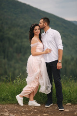 Groom and bride walking hougt the Carpathian mountains