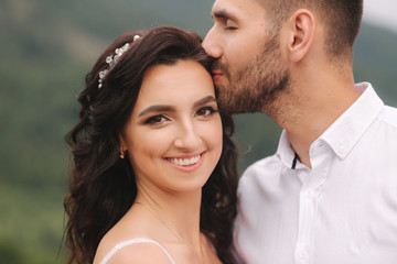 Close up portrait of beautiful couple in mountains. Happy woman with man. Elegant female with her husband