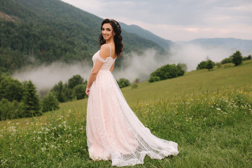 Fototapeta premium Charming bride in beautiful Carpathian mountais. Elegant woman in beautiful dress