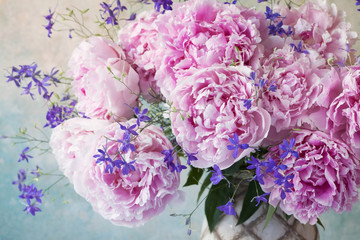 Bouquet of pink peonies and delphiniums in a vase, blur, soft focus, close-up