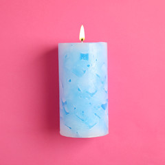Alight scented wax candle on color background