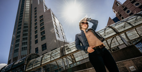 Lonely Modern woman straightens loose white hair. Life in a big city