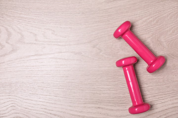Vinyl dumbbells and space for text on wooden background, flat lay