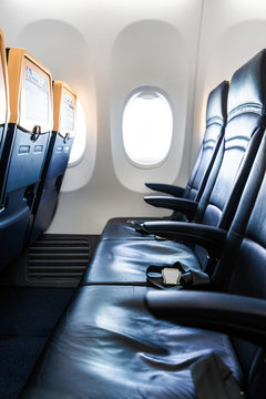 Plane interior - cabin with modern leather chair for passenger of airplane. Aircraft seats and window. - Vertical image