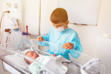 Baby brother and premature born infant child crib