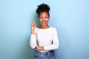 Attractive happy woman pointing by her index finger up