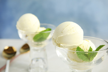 Delicious vanilla ice cream with mint served on table, closeup