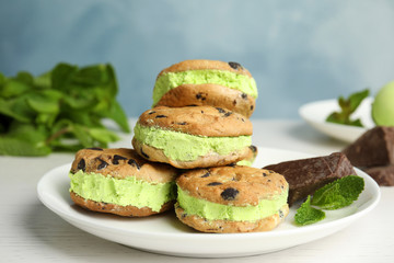 Plate with sweet delicious ice cream cookie sandwiches on table