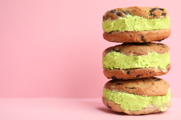 Sweet delicious ice cream cookie sandwiches on color background, space for text