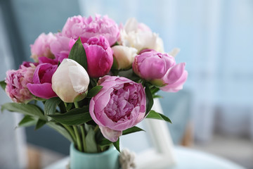 Bouquet of beautiful peonies in room, space for text