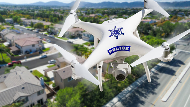Police Unmanned Aircraft System, (UAS) Drone Flying Above A Neighborhood and Street