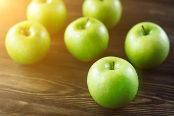 Group of green apples on brown wooden background. Close up