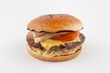 Classic american beef burger with juicy meat cutlet, greens, sauce cheddar and tomatoes, isolated on white background