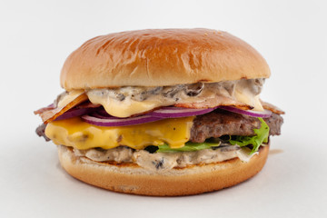 Classic american beef burger with juicy meat cutlet, greens, sauce cheddar and tomatoes, isolated on white background