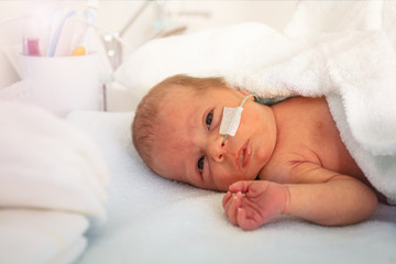 Portrait of a baby boy in ICU hospital crib