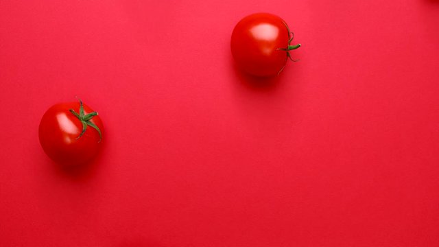 Cherry tomatoes, tomatoes rolling over a red background, top view, 4K, stop animation