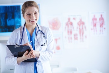 Woman doctor standing with folder at hospital