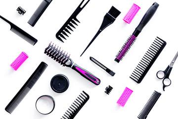 professional pink accessories of hairdresser with combs and sciccors on work desk white background top view pattern