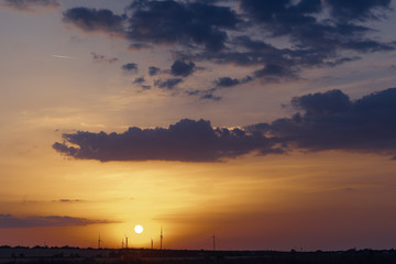Fototapeta na wymiar Wind power generators on the horizon against the backdrop of a beautiful sunset.