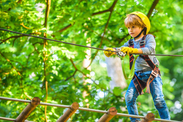 Child playing on the playground. Roping park. Active children. Safe Climbing extreme sport with...
