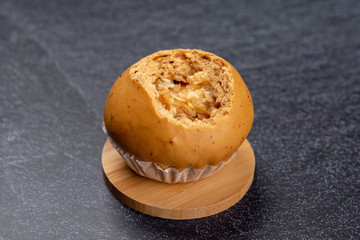 side view shredded coconut bun with a bite showing the inside