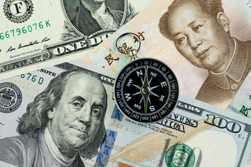 Compass on US America Dollar and Chinese Yuan banknotes using as tariff or trade war negotiation or future direction between the US and China concept