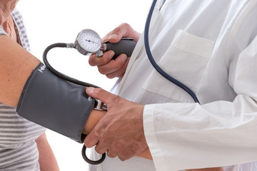 A medical doctor takes a patient s blood pressure.