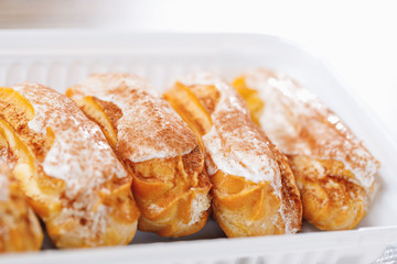 eclairs pastry in a plastic box, close-up view