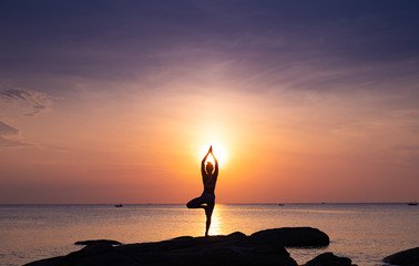 Asian girl practice Yoga on the beach Sunrise morning day