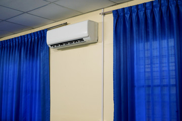 Air Conditioner between Window with Blue Curtains