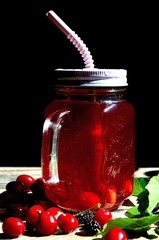 Compote of cherry and mulberry on a wooden table, sunny day.