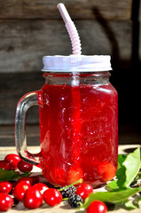 Compote of cherry and mulberry on a wooden table, sunny day.
