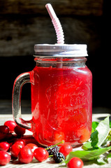 Compote of cherry and mulberry on a wooden table, sunny day.