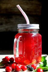 Compote of cherry and mulberry on a wooden table, sunny day.