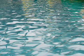 Blue transparent water waves and reflections in the pool