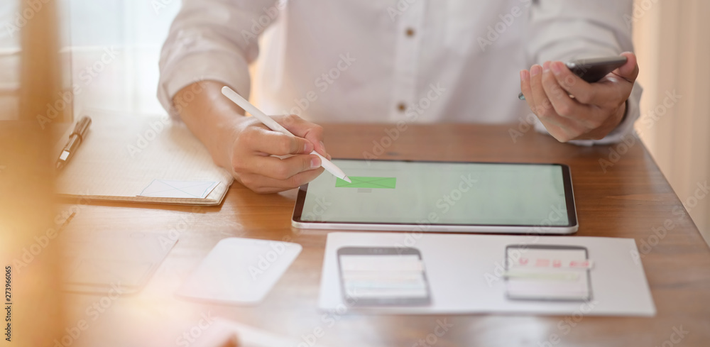 Wall mural ui ux designer planning application prototype wireframe on tablet and paperwork layout