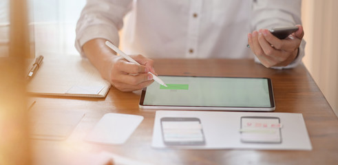 UI UX designer planning application prototype wireframe on tablet and paperwork layout